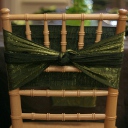 Natural wood chiavari chair wrapped with a moss crush sash.