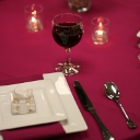 Raspberry linen with white plates and a glass of wine.